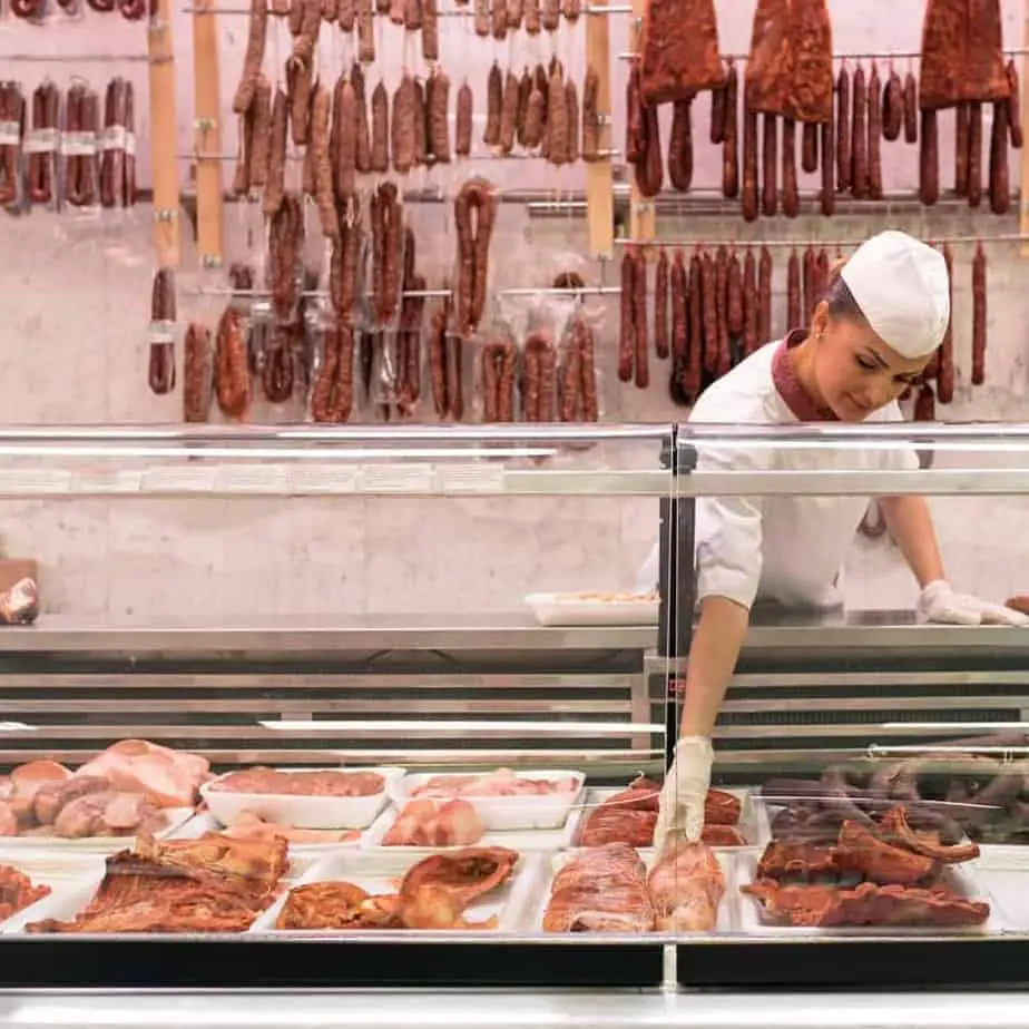 Woman Butcher Organizing Meats